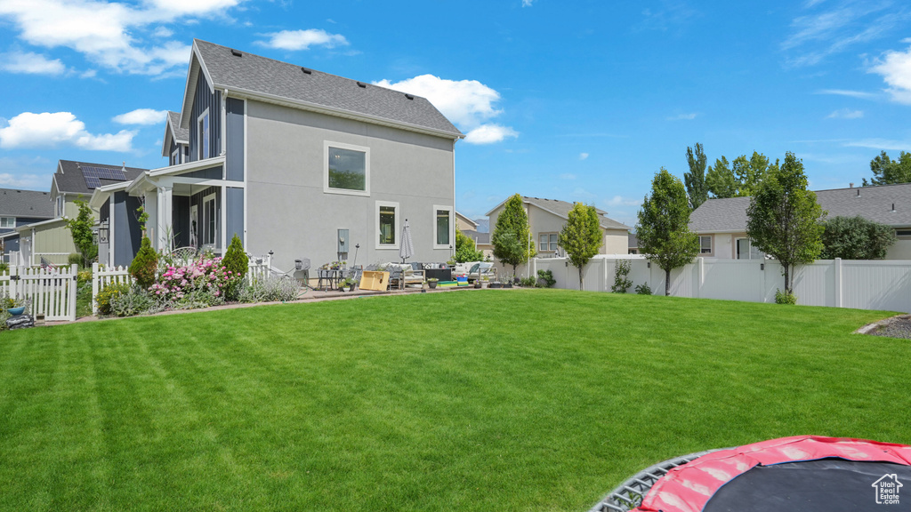 Rear view of house with a fenced backyard, a residential view, and stucco siding