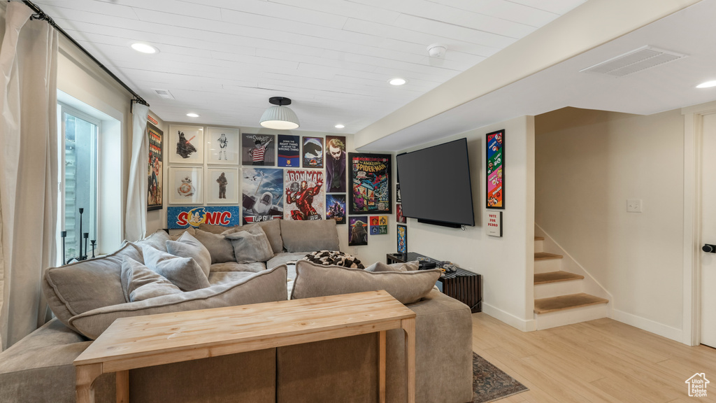 Living area featuring light wood finished floors, recessed lighting, and stairs