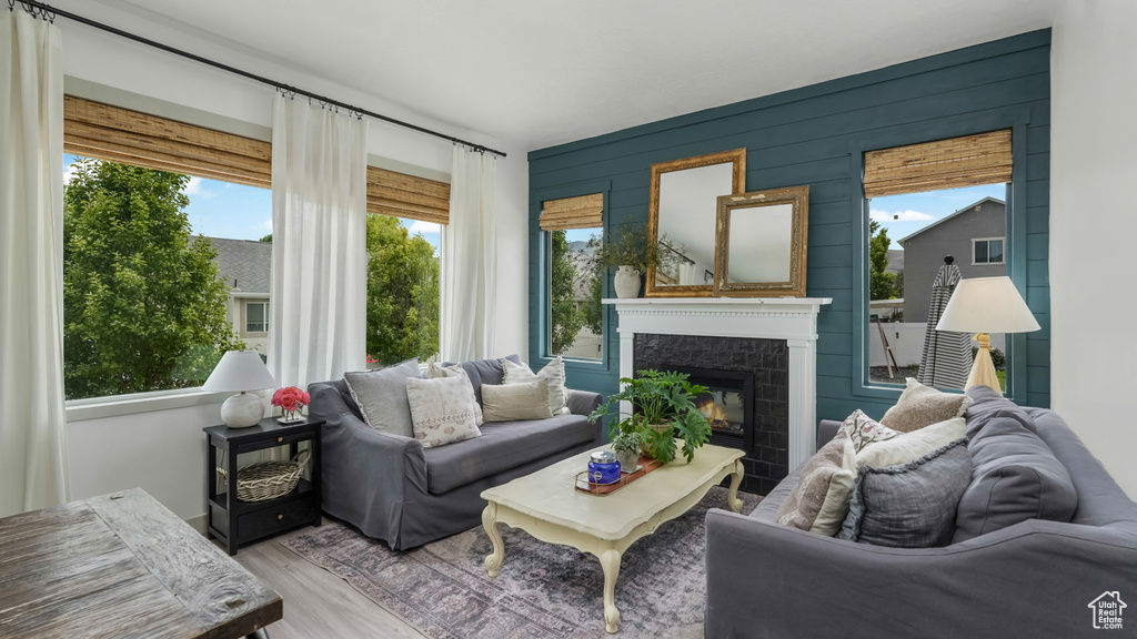 Living room with plenty of natural light, a high end fireplace, and wood finished floors