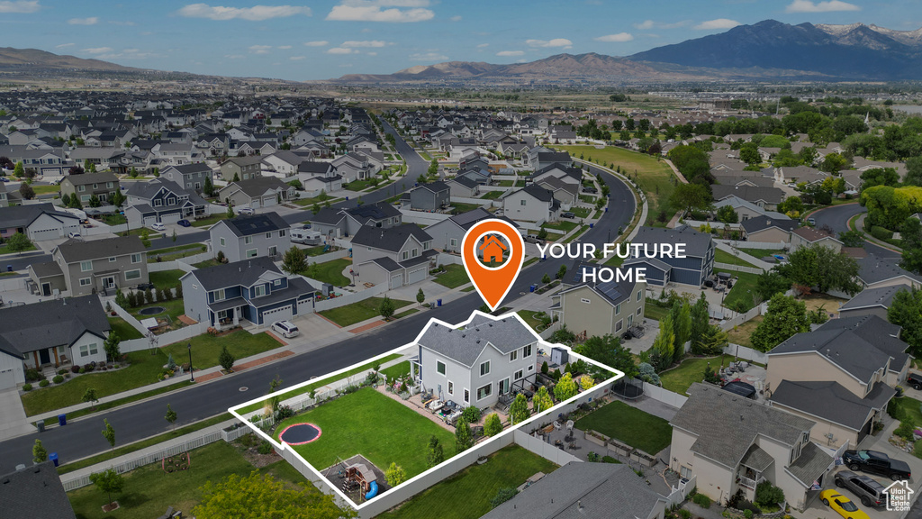 Aerial perspective of suburban area with property parcel outlined and a mountain backdrop