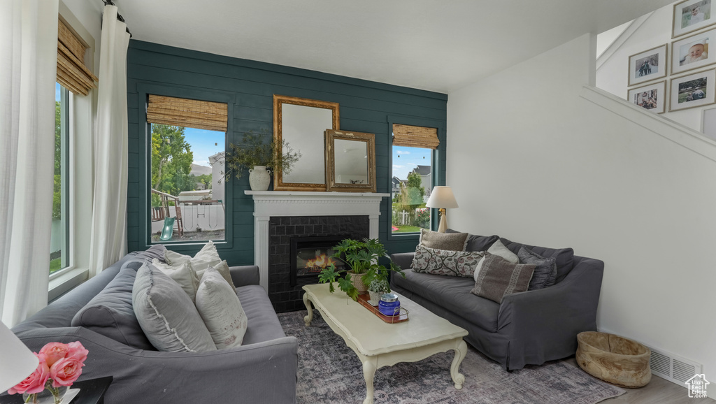 Living room with a glass covered fireplace and wood finished floors