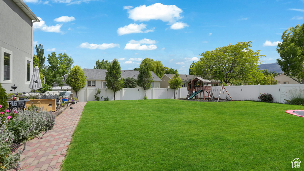Fenced backyard with a playground and a residential view