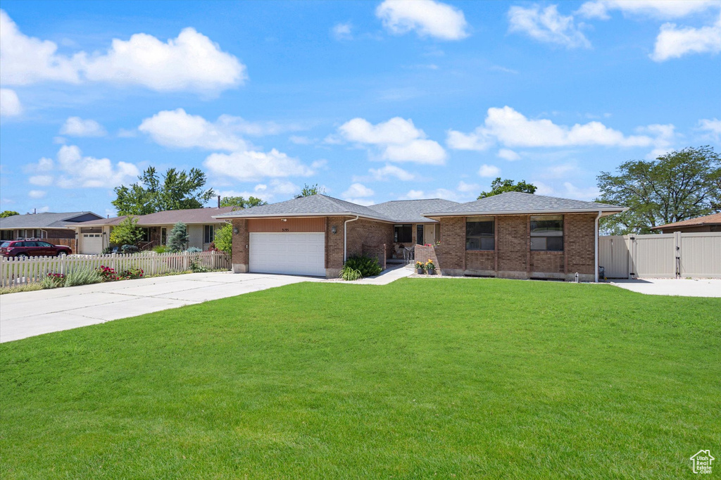 Ranch-style house featuring driveway, a garage, brick siding, and a gate