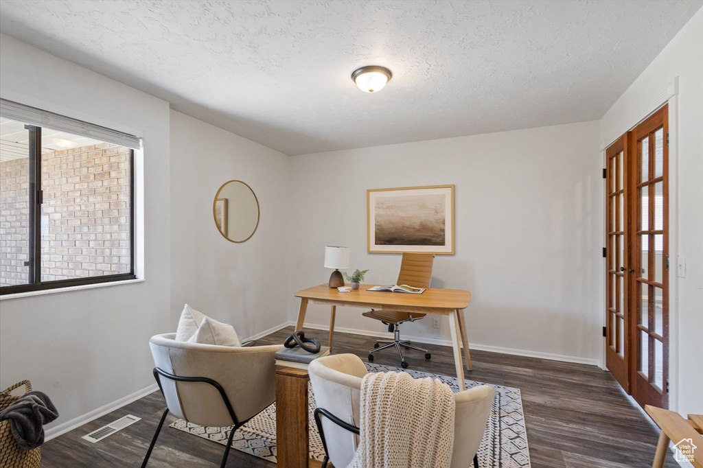 Home office featuring wood finished floors, a textured ceiling, baseboards, and plenty of natural light