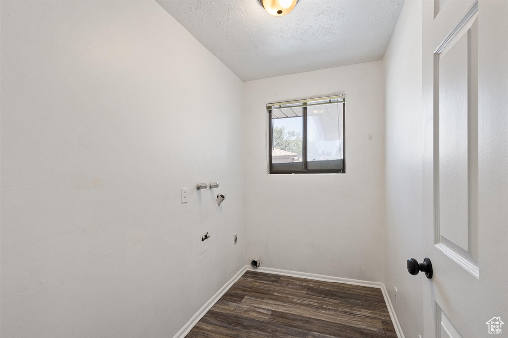 Laundry room with dark wood finished floors, baseboards, and hookup for a washing machine