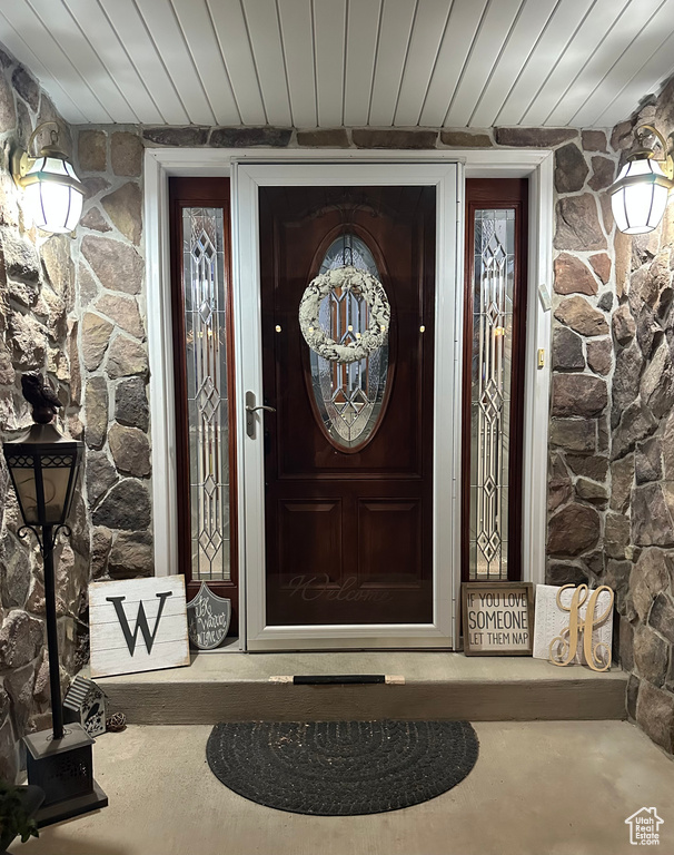 Doorway to property featuring stone siding