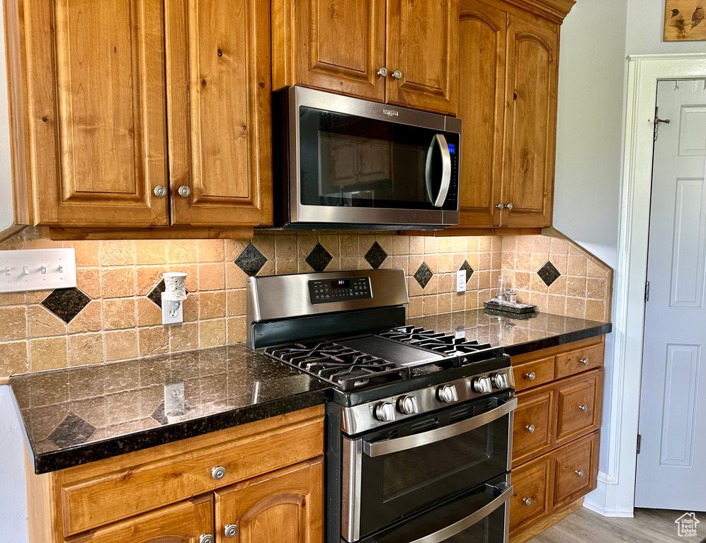 Kitchen featuring appliances with stainless steel finishes and brown cabinets