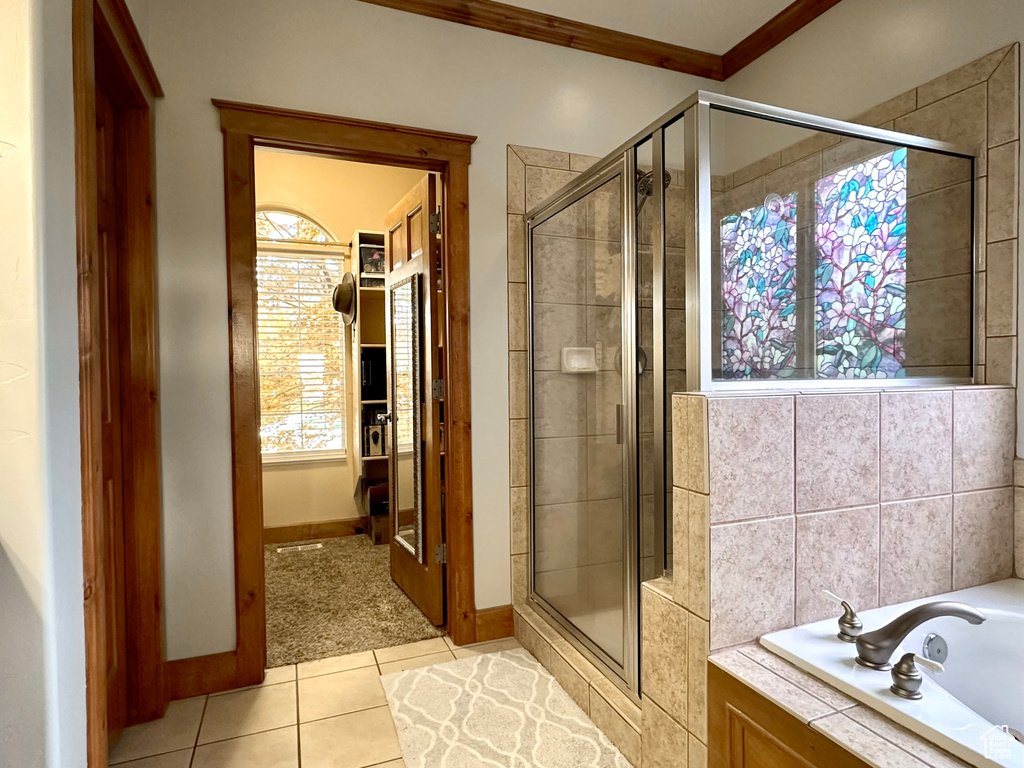 Bathroom featuring ornamental molding, a stall shower, tile patterned flooring, a bath, and baseboards
