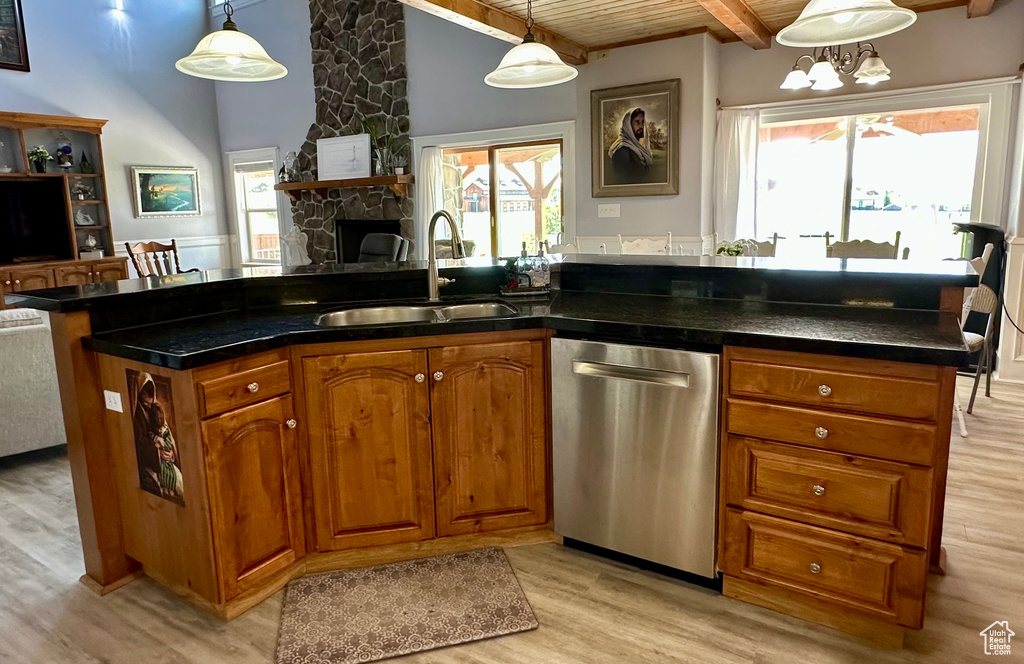Kitchen with dishwasher, a sink, brown cabinetry, light wood-style flooring, and open floor plan