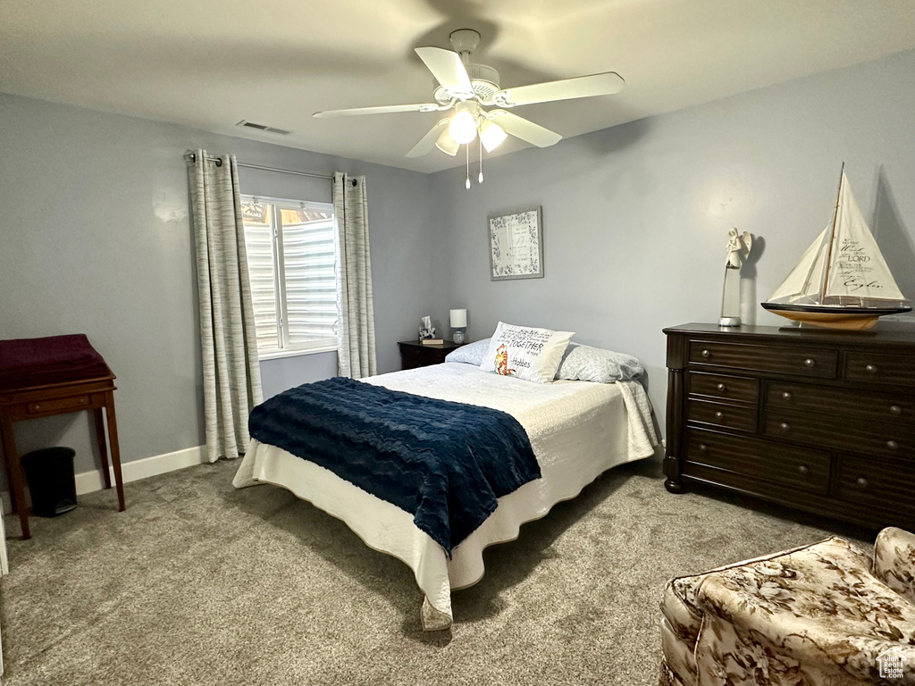 Bedroom with light colored carpet, a ceiling fan, and baseboards