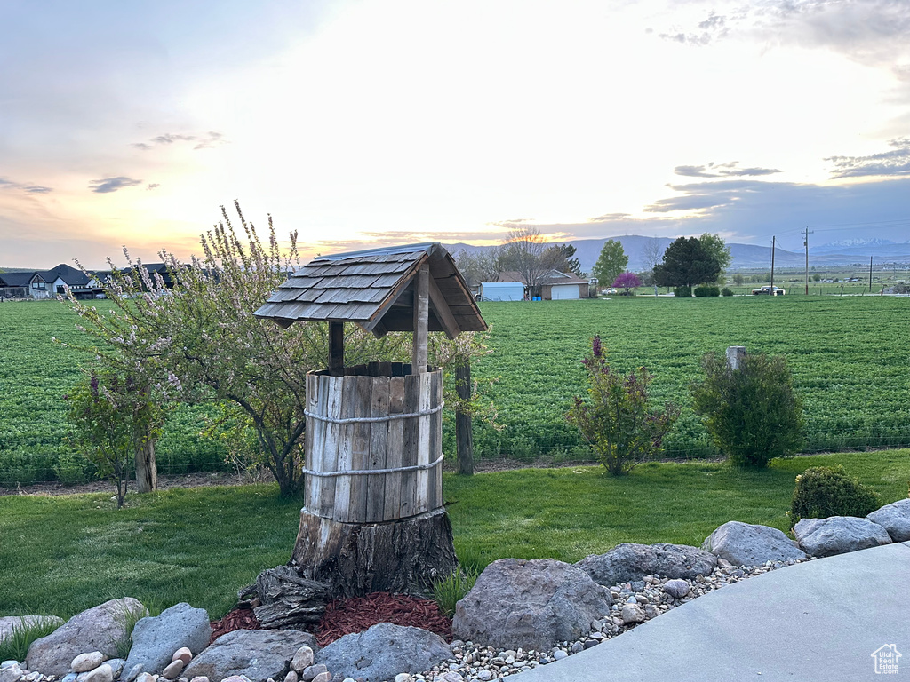 Yard at dusk with a lawn and a mountain view