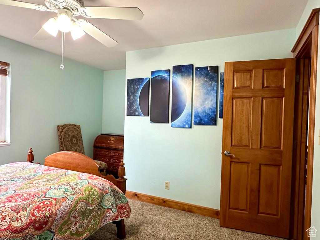 Bedroom with carpet flooring, baseboards, and a ceiling fan