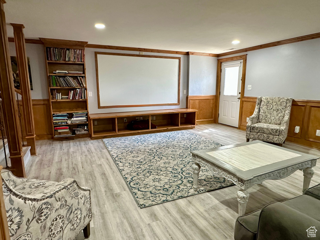 Living room featuring a wainscoted wall, ornamental molding, light wood-style flooring, and recessed lighting