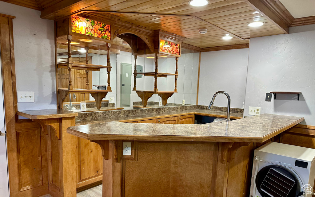 Kitchen with wooden ceiling, a peninsula, a kitchen bar, recessed lighting, and ornamental molding