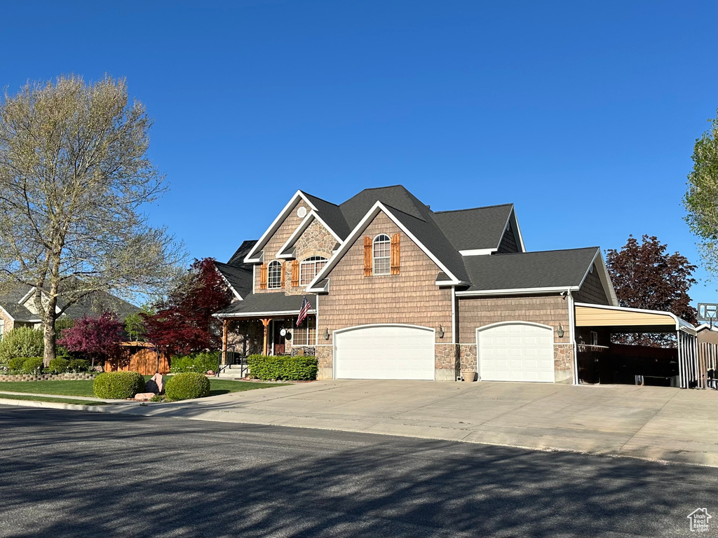View of front of house featuring concrete driveway and a carport