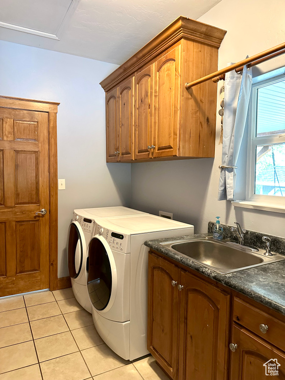 Laundry area with cabinet space, light tile patterned floors, and separate washer and dryer