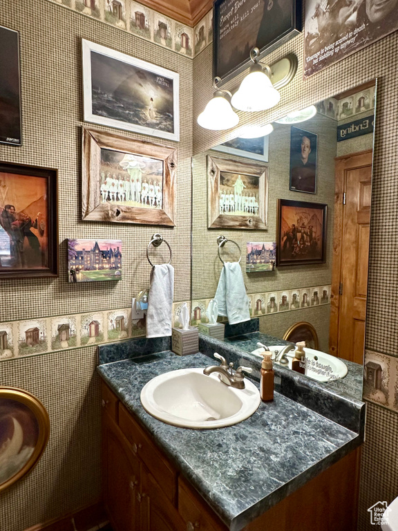 Bathroom featuring wallpapered walls and vanity