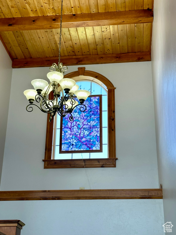 Detailed view of a chandelier and wood ceiling with exposed beams
