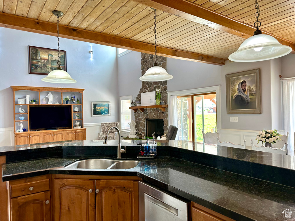 Kitchen featuring a sink, wood ceiling, open floor plan, stainless steel dishwasher, and brown cabinets