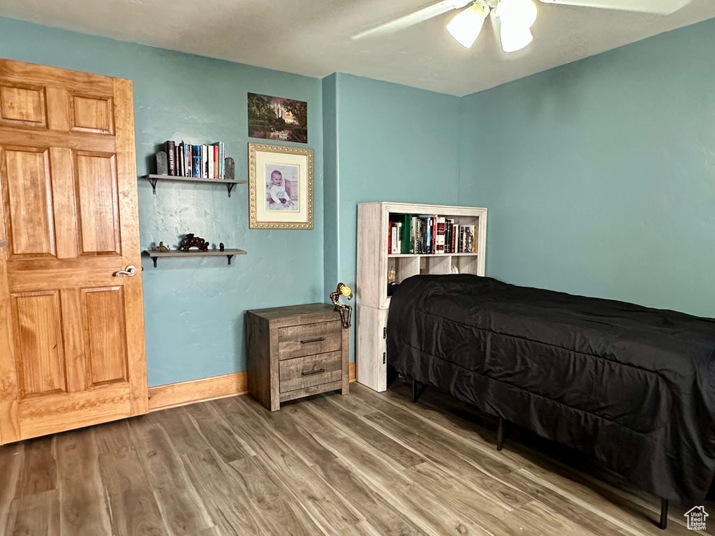 Bedroom featuring wood finished floors, a ceiling fan, and baseboards