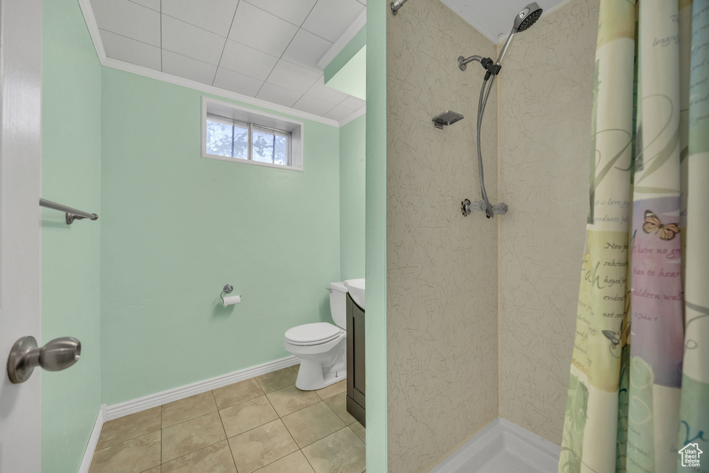 Bathroom with crown molding, a shower with shower curtain, vanity, and tile patterned floors