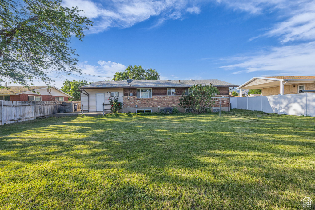 Rear view of property featuring a fenced backyard and brick siding
