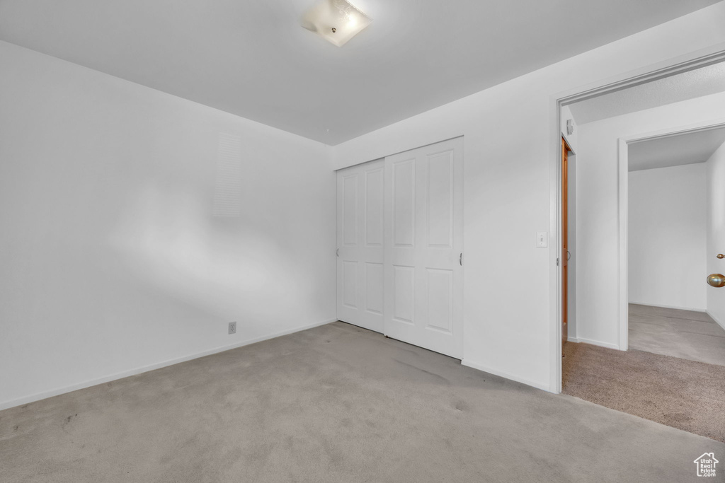 Unfurnished bedroom with carpet and a closet