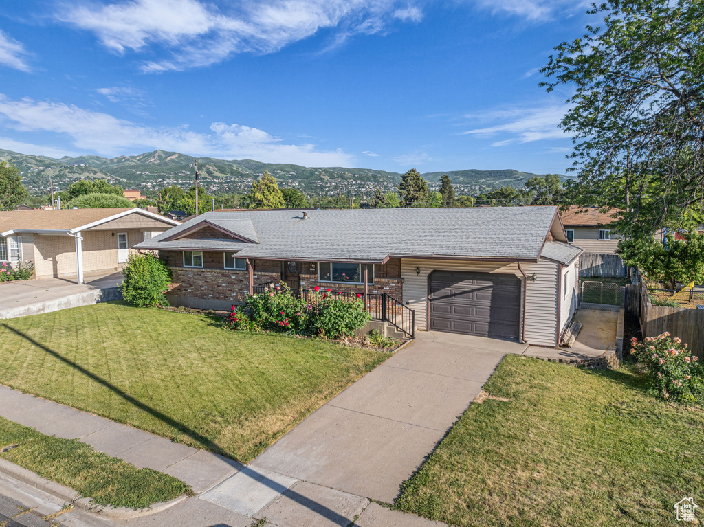 Ranch-style house featuring a garage, a porch, a mountain view, and concrete driveway