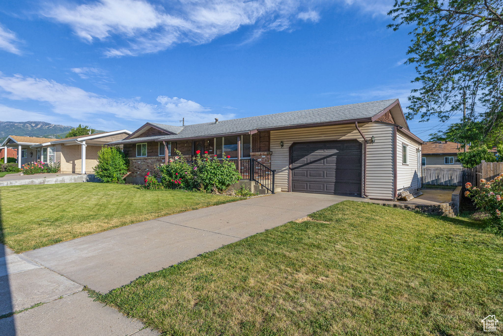 Ranch-style house featuring a garage, covered porch, and driveway