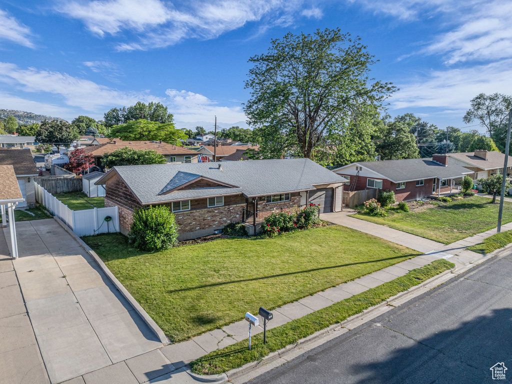 Single story home with driveway, a residential view, and brick siding