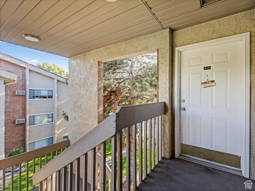Doorway to property with stucco siding and a balcony