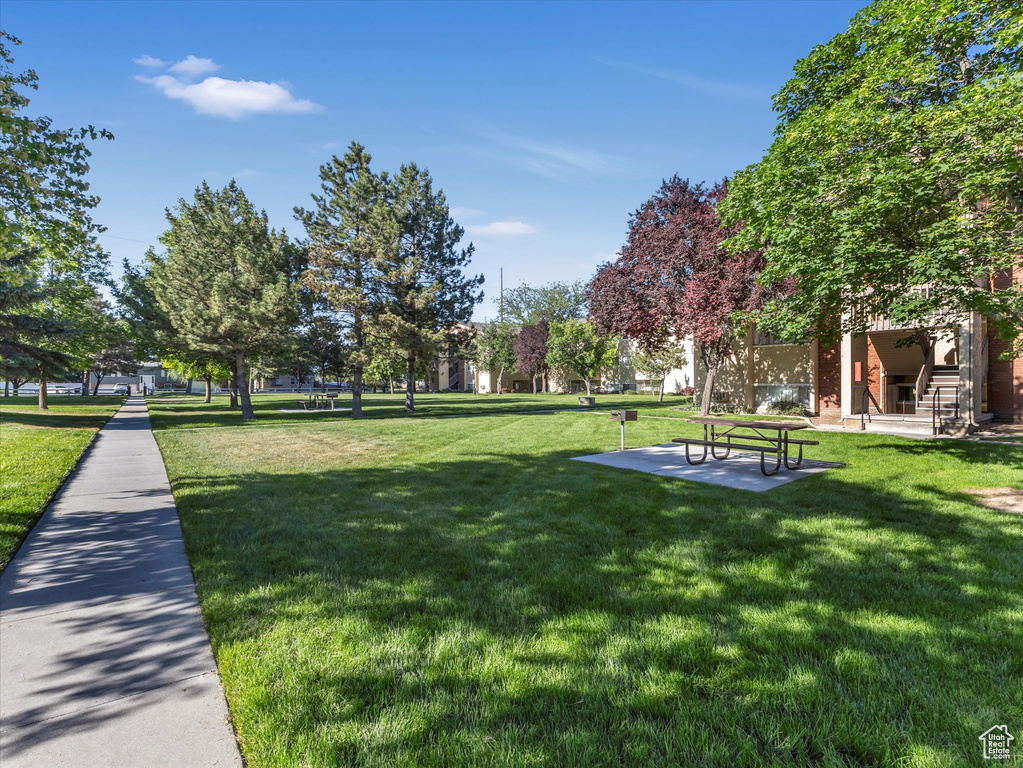 Surrounding community with a lawn and a patio area
