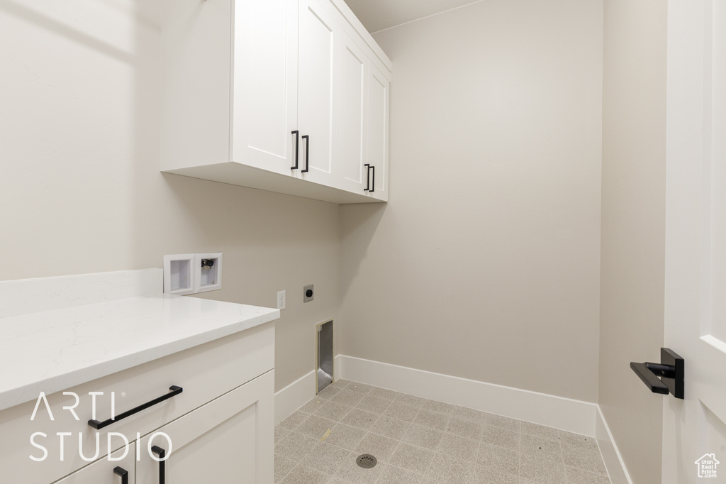 Washroom featuring cabinet space, baseboards, electric dryer hookup, and washer hookup