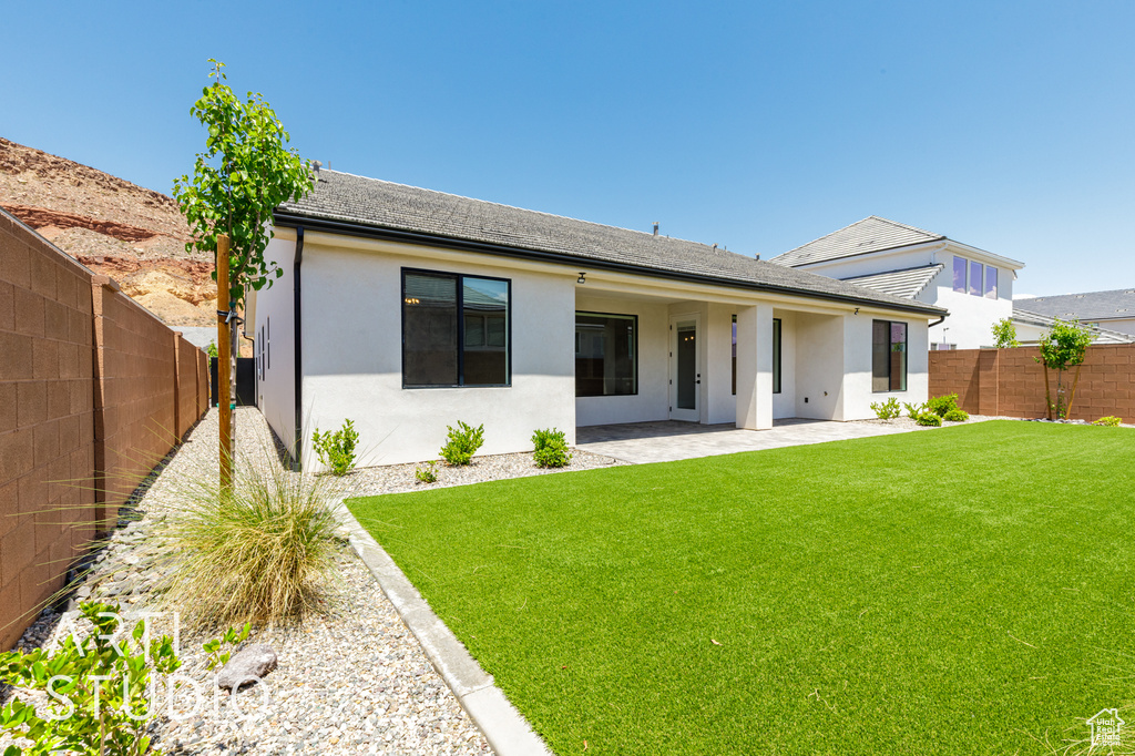 Back of property with stucco siding, a patio area, and a shingled roof