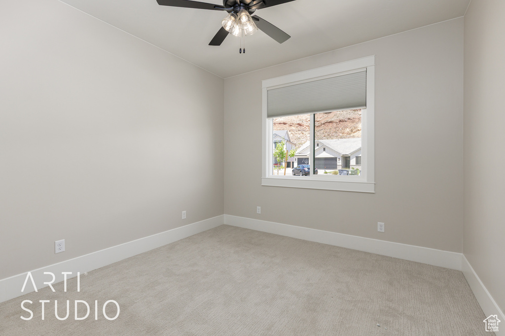Empty room with carpet, ceiling fan, and baseboards