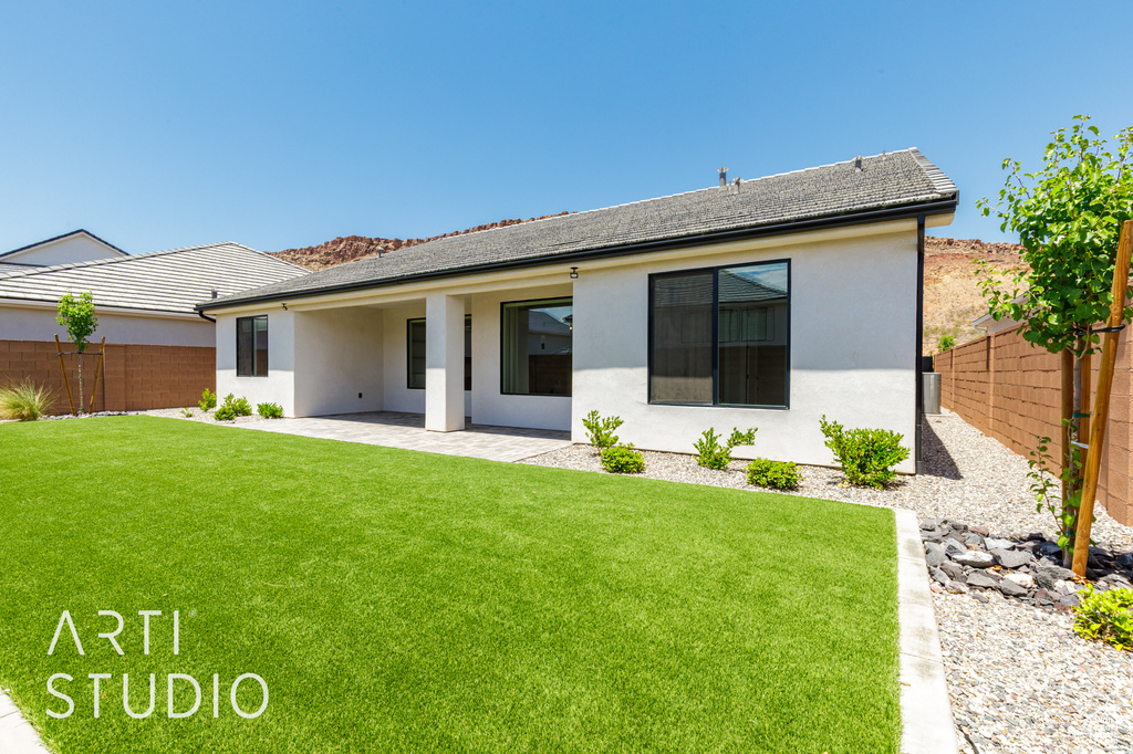 Rear view of property featuring stucco siding and a patio area