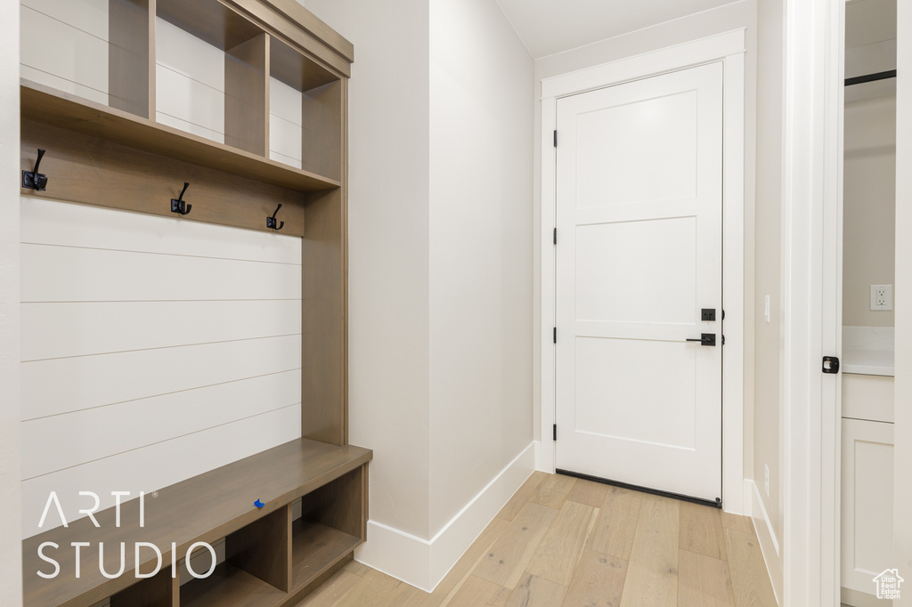 Mudroom with light wood-style floors and baseboards