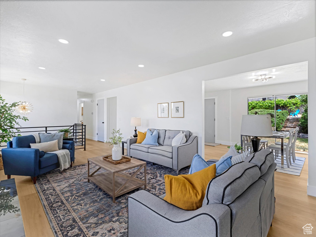Living room featuring a chandelier, light wood-style flooring, and recessed lighting