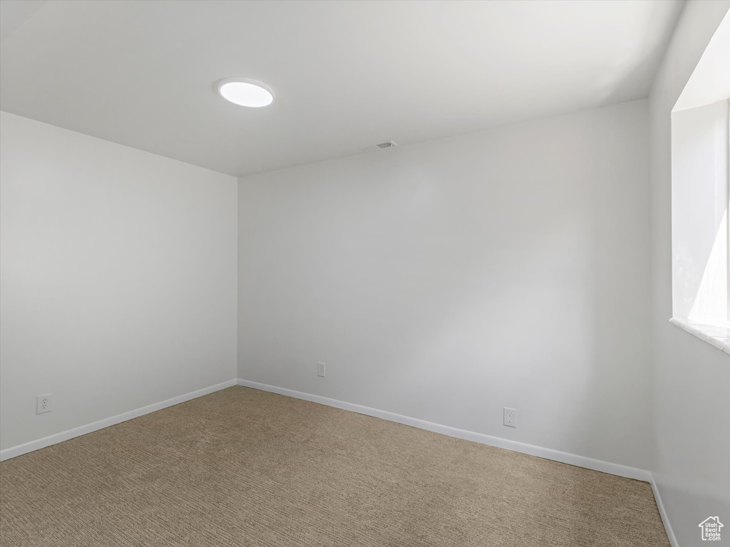 Empty room featuring light colored carpet
