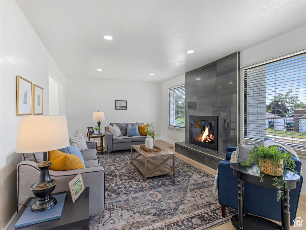Living room featuring wood finished floors, a large fireplace, and recessed lighting