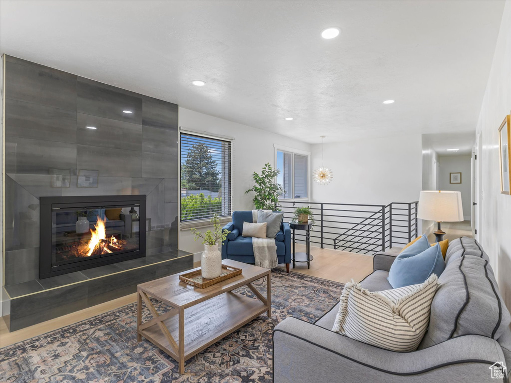 Living room featuring wood finished floors, recessed lighting, and a large fireplace