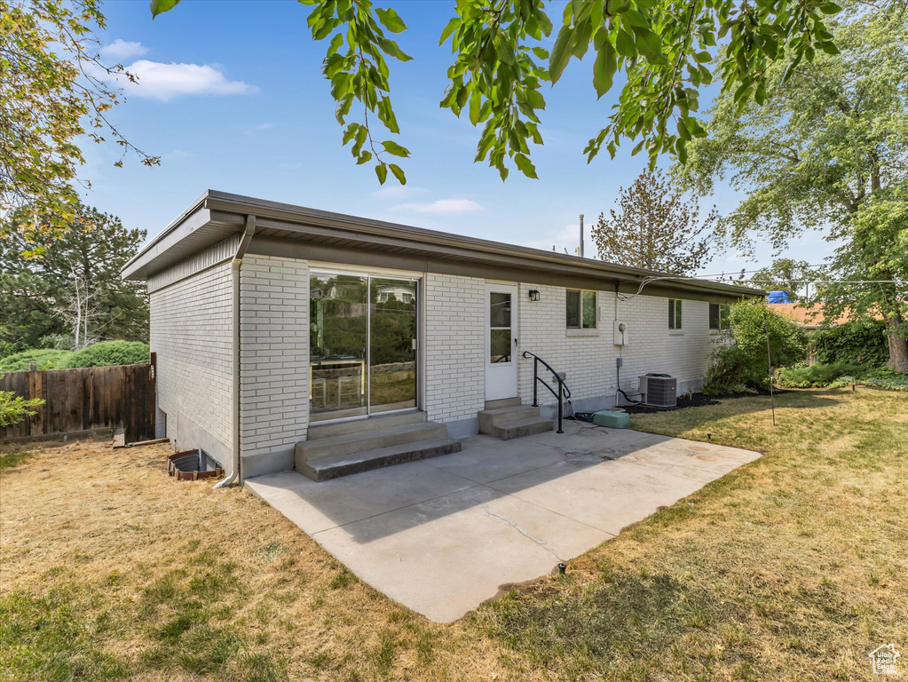 Back of house with entry steps, brick siding, and a patio