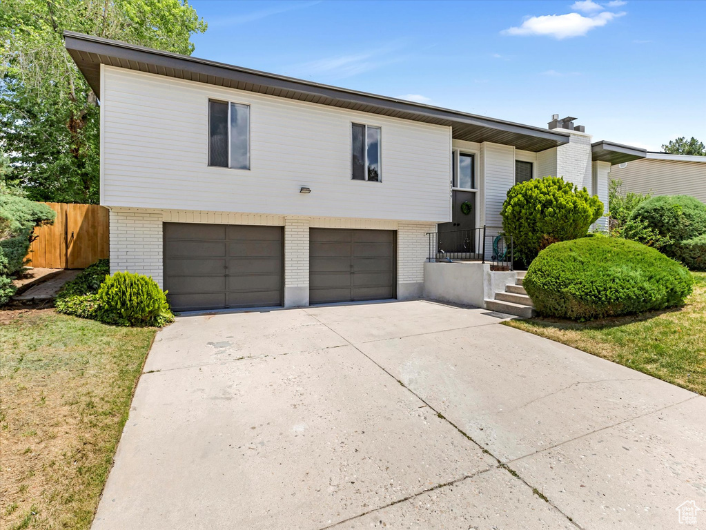 View of front facade featuring brick siding, an attached garage, and concrete driveway