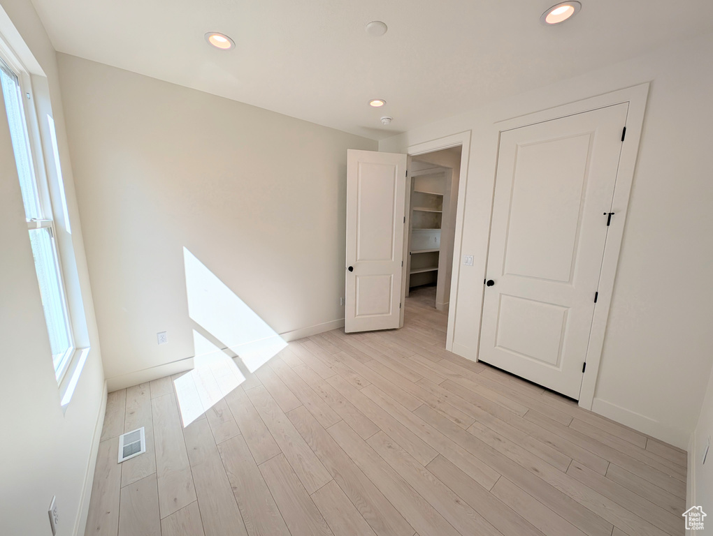 Unfurnished bedroom featuring multiple windows, recessed lighting, and light wood-type flooring
