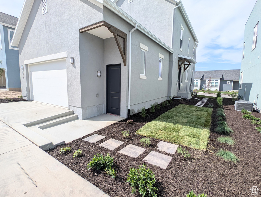 View of front of home with a garage, stucco siding, and concrete driveway