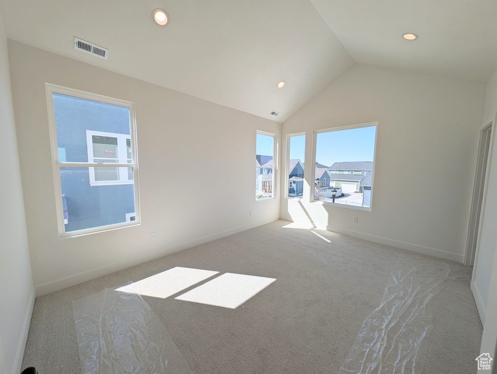 Carpeted empty room featuring lofted ceiling and recessed lighting