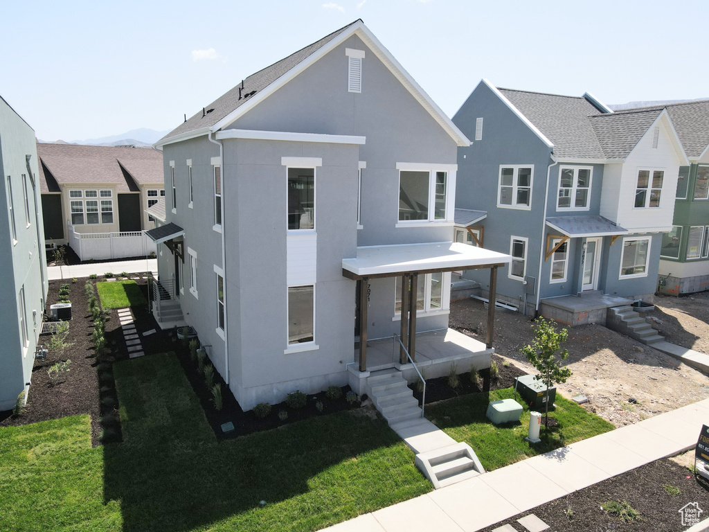 View of front of house featuring stucco siding and a front yard