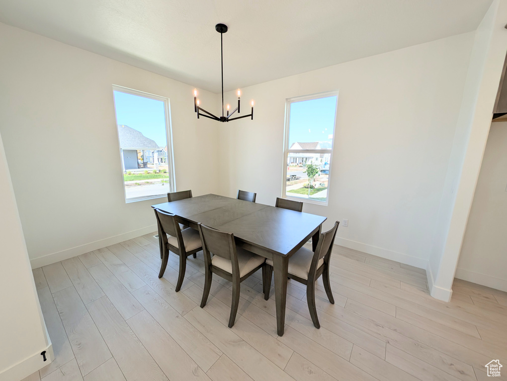 Dining space featuring a chandelier, healthy amount of natural light, and light wood finished floors