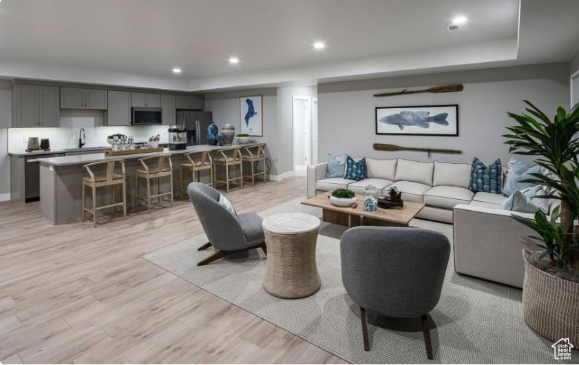Living room with light wood-type flooring and recessed lighting
