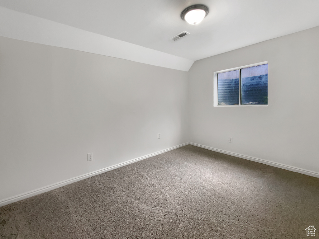 Spare room with lofted ceiling and carpet